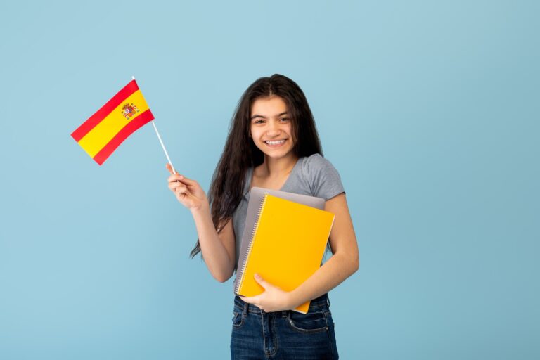 The happy student of Ardevaz SLS is holding a Spanish flag.
